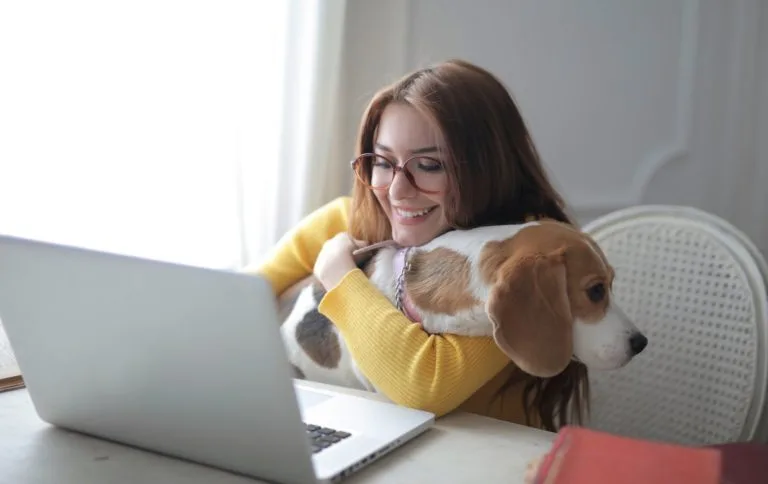 Woman consulting an online vet for her dog through a video call on her laptop